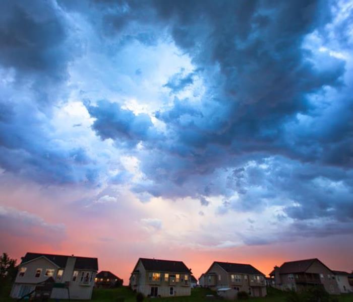 A photo of storm clouds forming above a suburban neighborhood