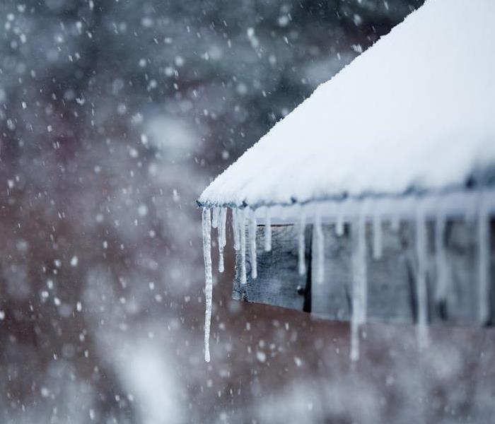 Icicles hanging off a roof in a snowstorm